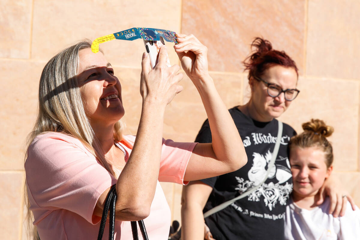Jan Pickens takes a photo of the annular solar eclipse as it passes over Las Vegas on Saturday, ...