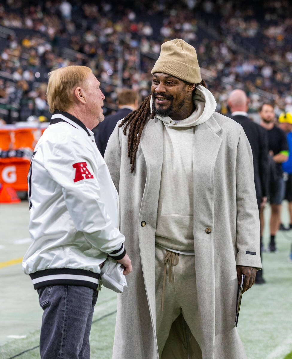 Raiders owner Mark Davis chats with former player Marshawn Lynch on the sidelines before facing ...
