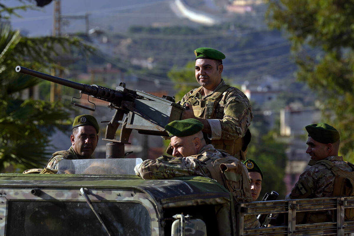 Lebanese army soldiers sit on their armored vehicle as they patrol the Lebanese side of the Leb ...