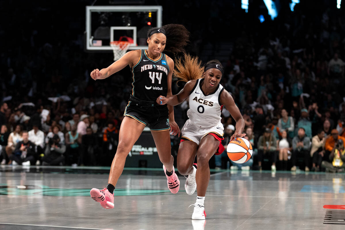 Las Vegas Aces guard Jackie Young (0) dribbles up the court while colliding with New York Liber ...