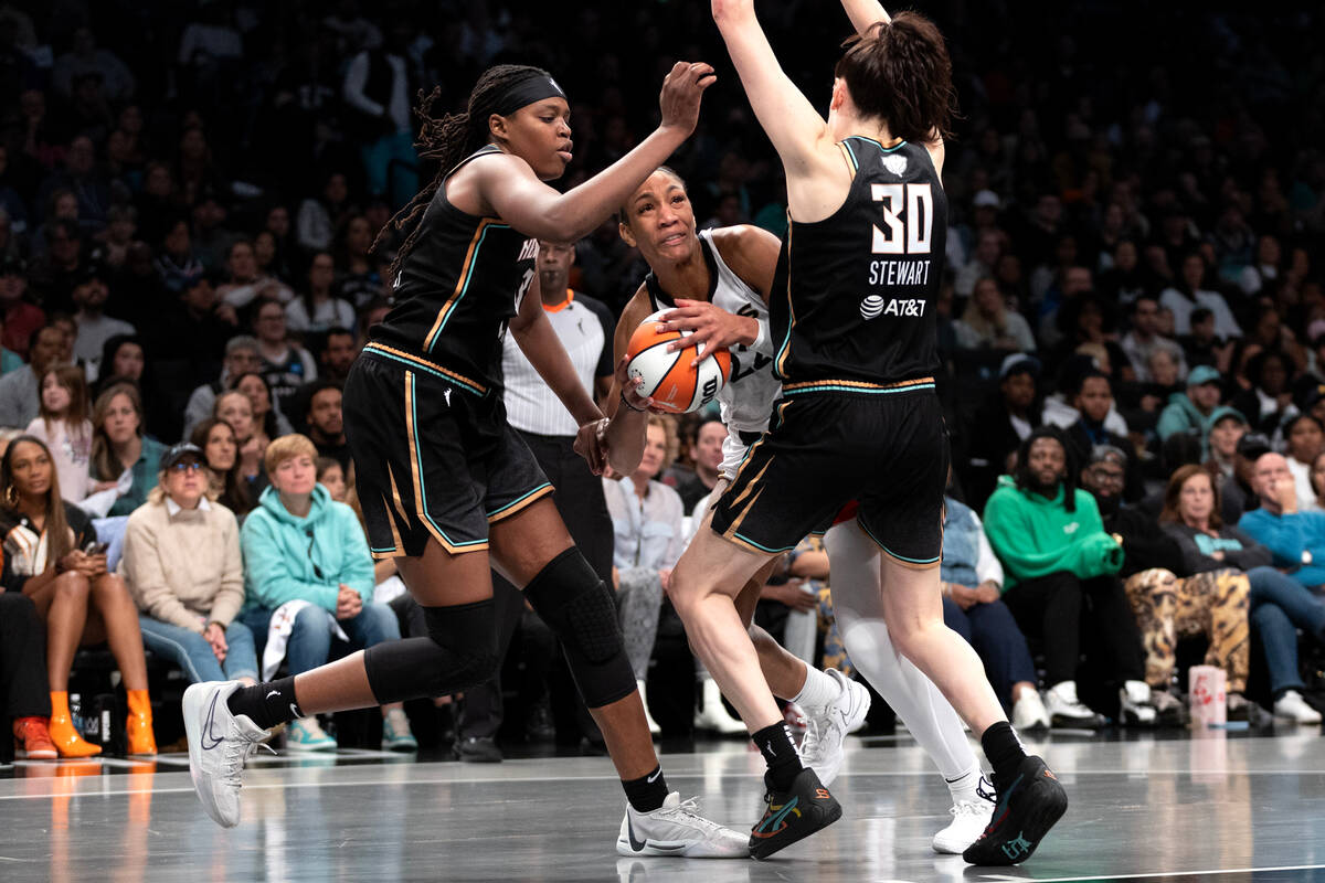 New York Liberty forwards Jonquel Jones, left, and Breanna Stewart (30) surround Las Vegas Aces ...