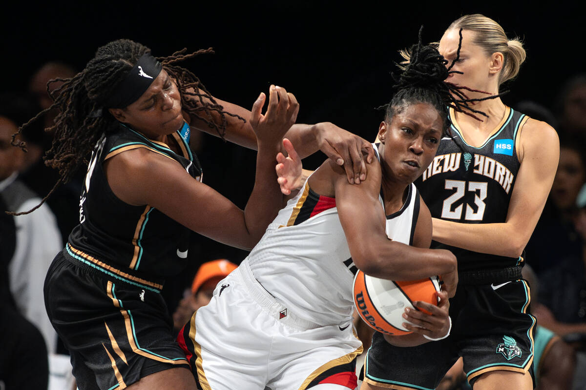 Las Vegas Aces guard Chelsea Gray (12) struggles for the ball with New York Liberty forward Jon ...