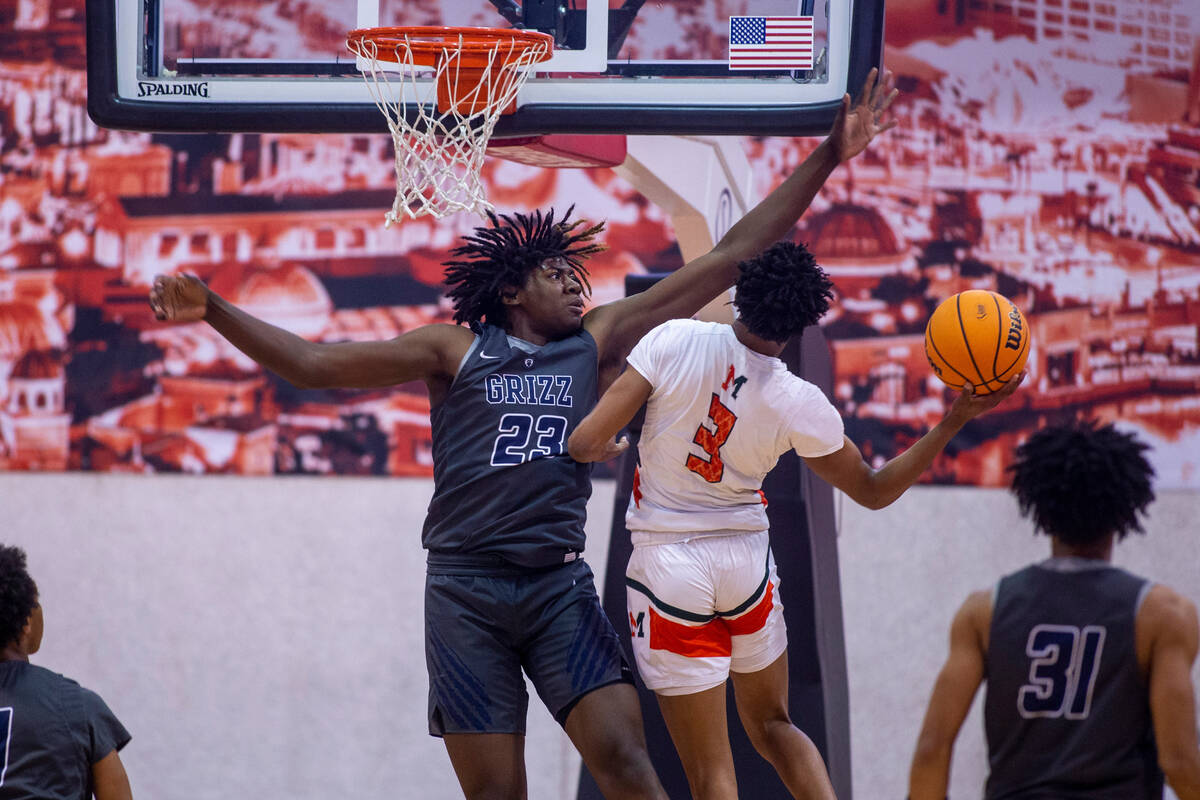 Spring Valley forward Pharaoh Compton (23) extends to reject a shot by Mojave guard Christopher ...