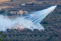 A shell from Israeli artillery explodes over a house in al-Bustan, a Lebanese border village wi ...