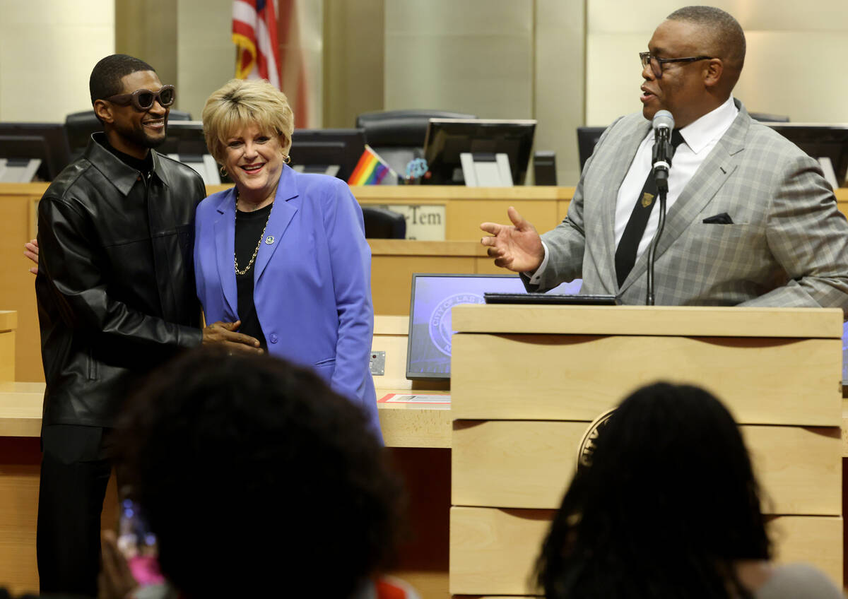 Usher Raymond IV, left, hugs Las Vegas Mayor Carolyn Goodman as Councilman Cedric Crear speaks ...