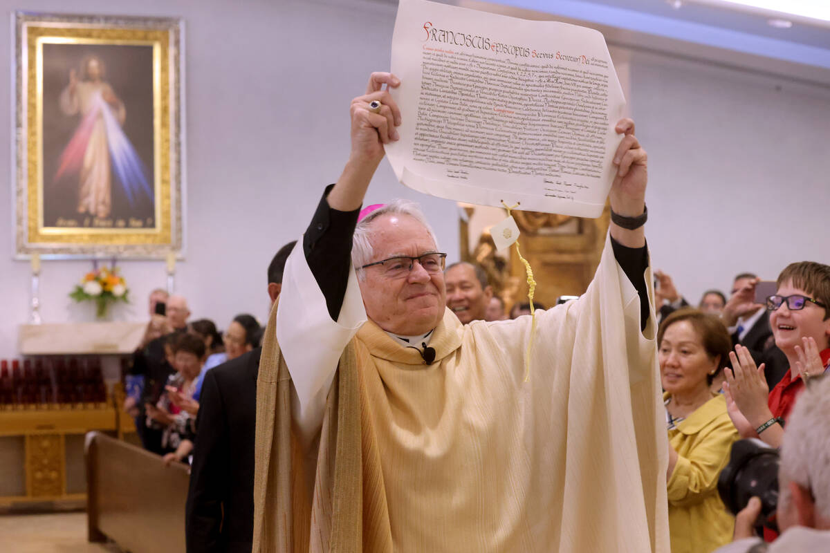 Archbishop George Leo Thomas holds the papal bull that had just been read by Christophe Cardina ...