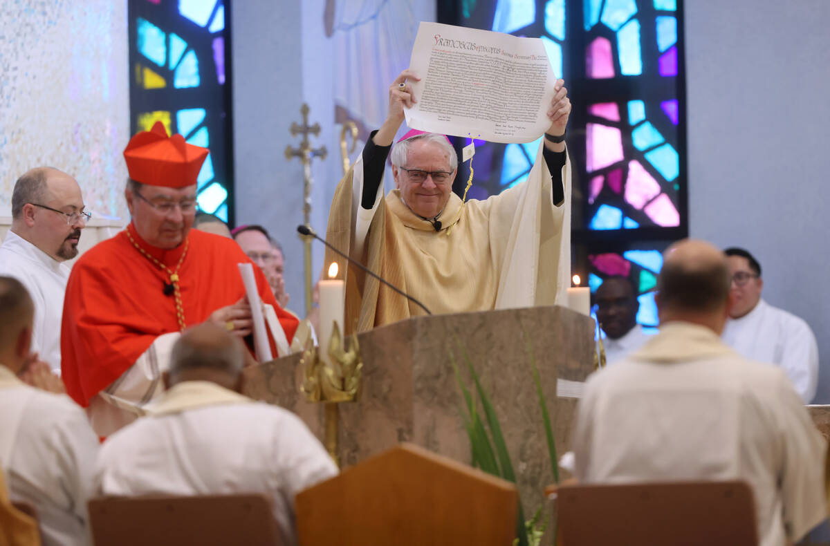 Archbishop George Leo Thomas holds the papal bull that had just been read by Apostolic Nuncio t ...