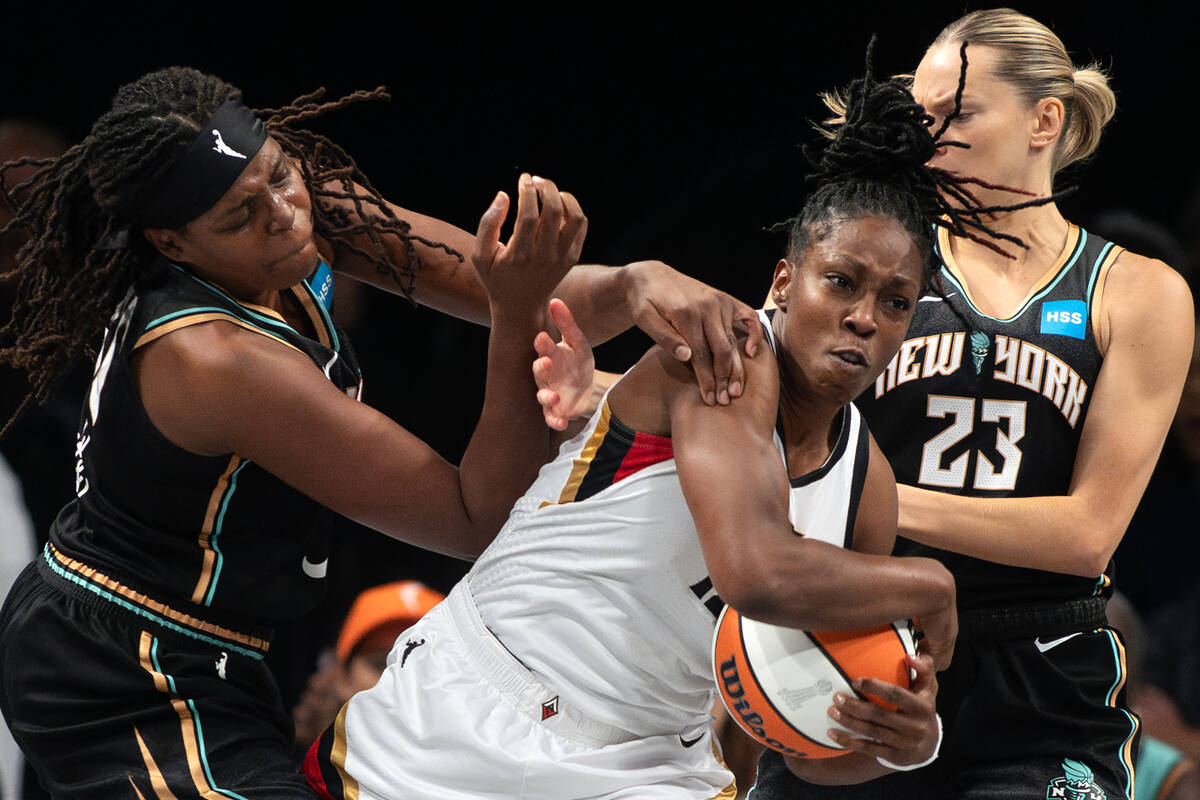 Las Vegas Aces guard Chelsea Gray (12) struggles for the ball with New York Liberty forward Jon ...