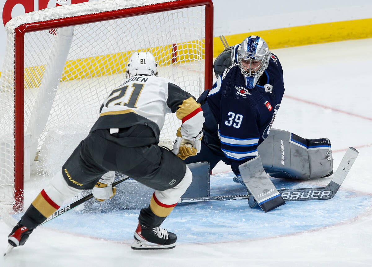 Vegas Golden Knights' Brett Howden (21) scores against Winnipeg Jets goaltender Laurent Brossoi ...