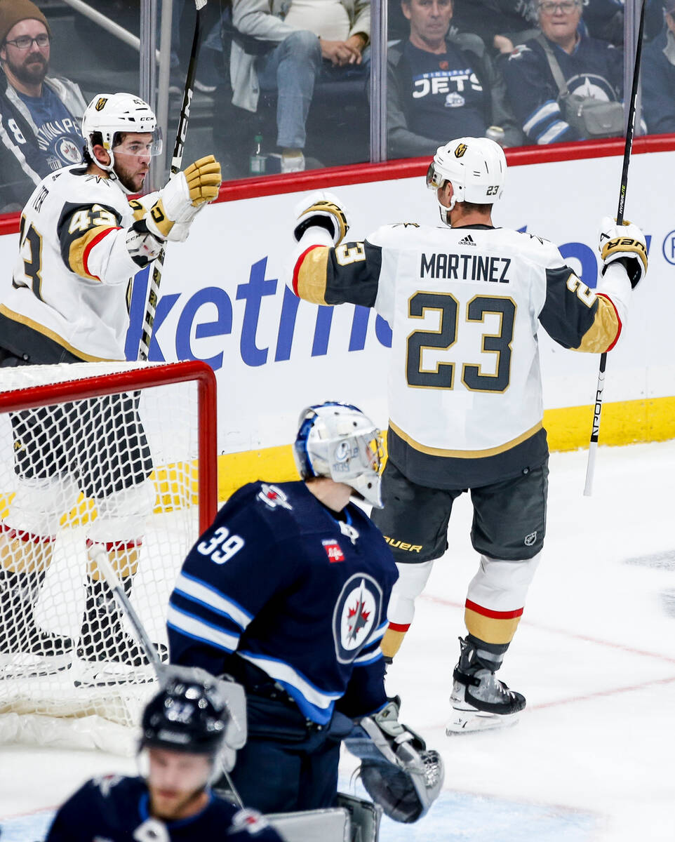 Vegas Golden Knights' Paul Cotter (43) and Alec Martinez (23) celebrate after Martinez's goal a ...