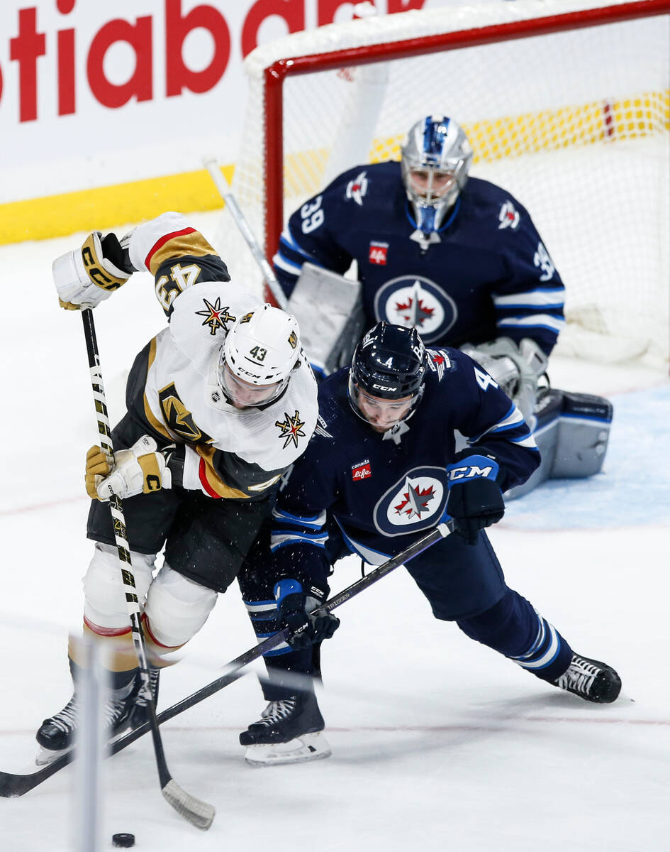Winnipeg Jets' Neal Pionk (4) defends against Vegas Golden Knights' Paul Cotter (43) during sec ...