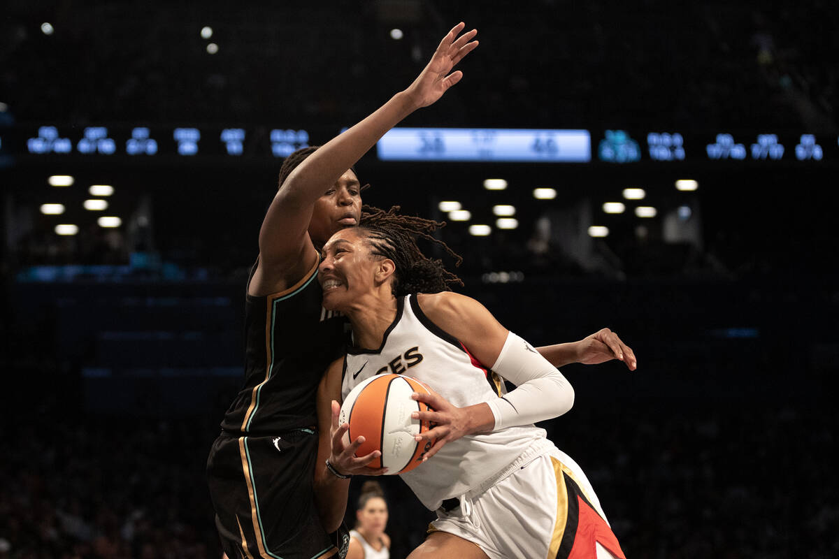 Las Vegas Aces forward A'ja Wilson (22) powers through the defense of New York Liberty forward ...