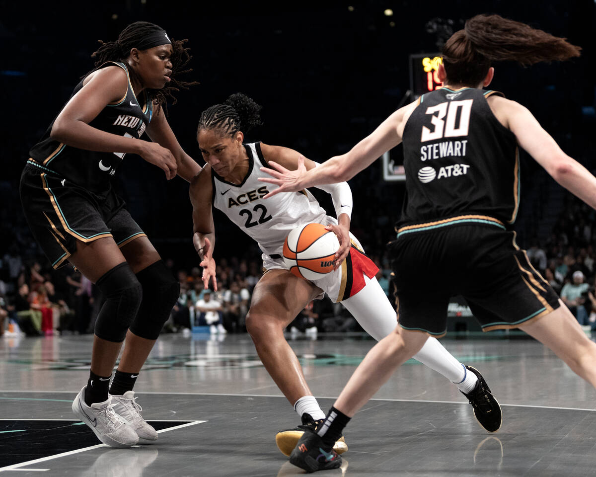 Las Vegas Aces forward A'ja Wilson (22) dribbles between New York Liberty forward Jonquel Jones ...