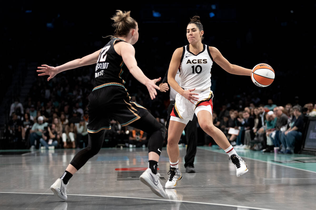 Las Vegas Aces guard Kelsey Plum (10) starts to pass around New York Liberty guard Courtney Van ...