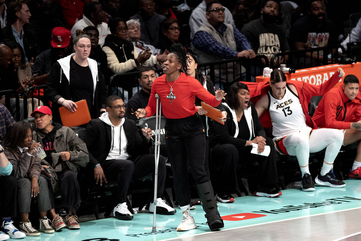 Las Vegas Aces guard Chelsea Gray, who was injured in Game 3, instructs her team from the sidel ...