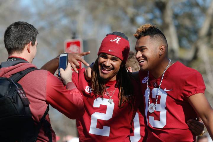FILE - Alabama quarterbacks Jalen Hurts, center, and Tua Tagovailoa have their picture taken du ...