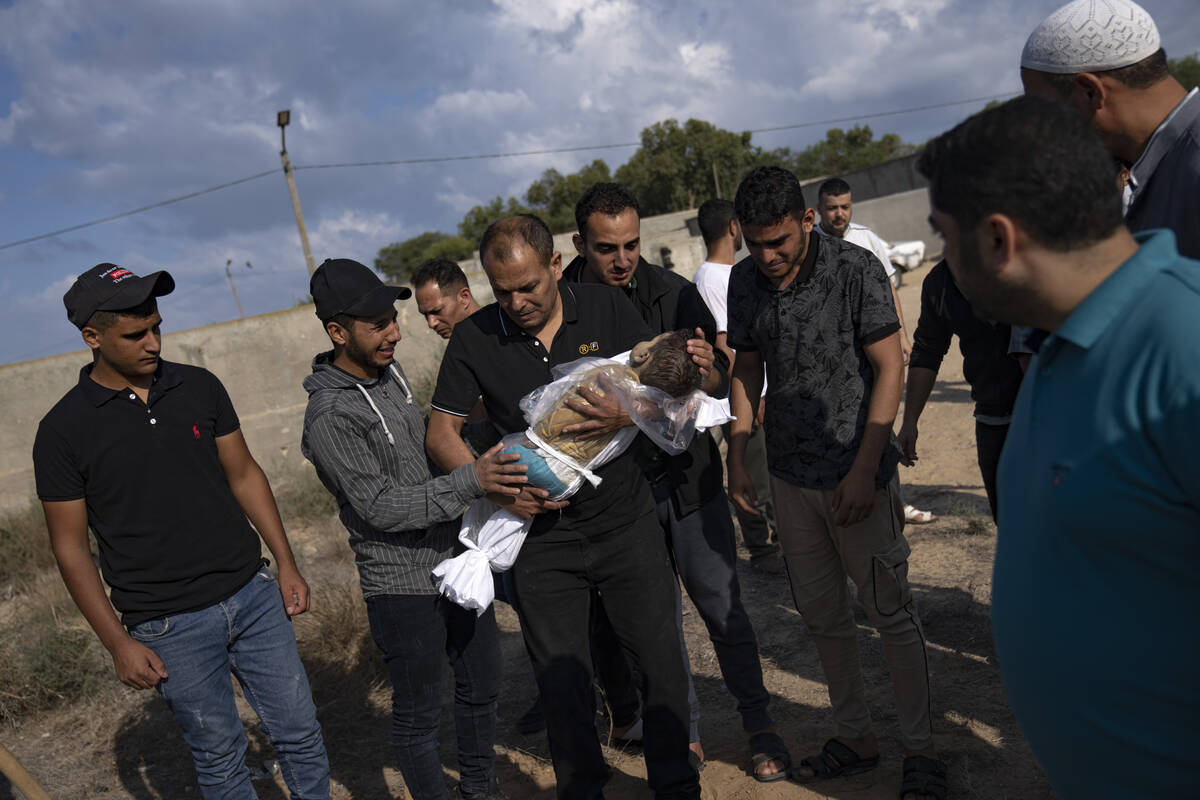 A Palestinian man holds the body of his nephew killed in the Israeli bombardment of the Gaza St ...
