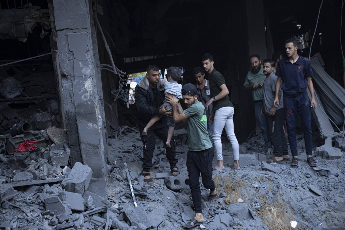 Palestinians evacuate wounded from a building destroyed in an Israeli bombardment in Khan Youni ...