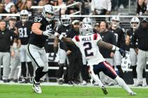 Las Vegas Raiders tight end Michael Mayer, left, runs with the ball after a reception as New En ...