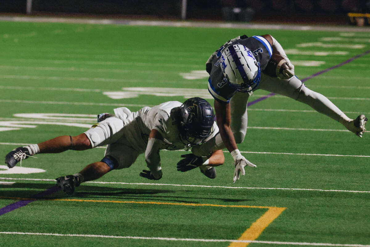 Basic running back Brandon Griffin (3) tries to free himself from the grip of Foothill cornerba ...