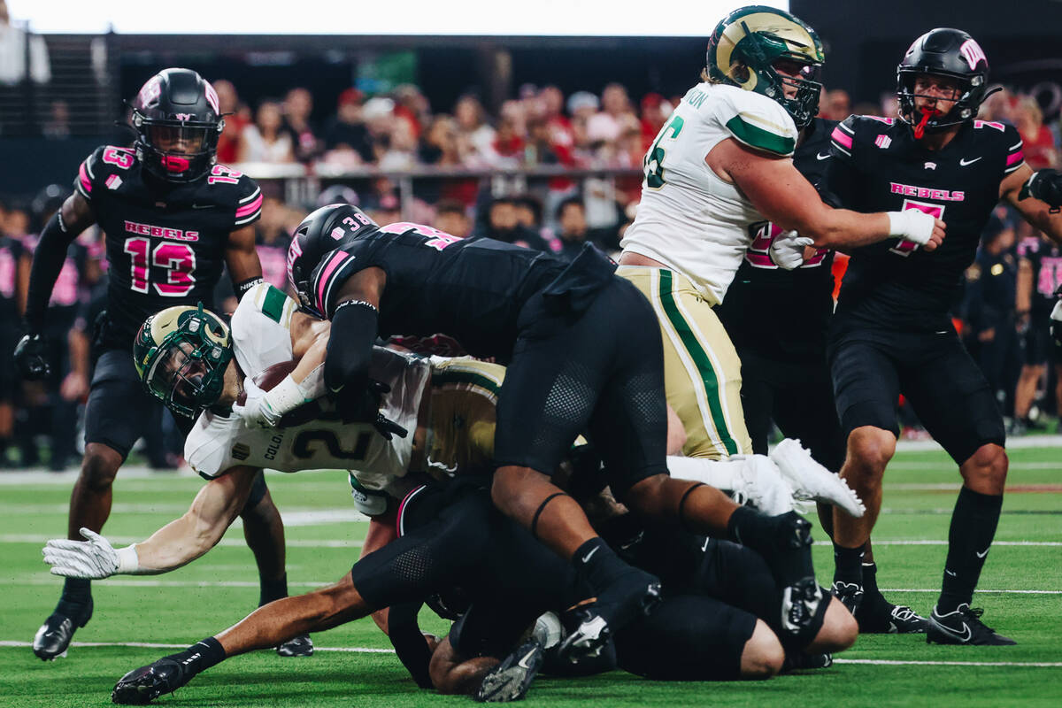 Colorado State running back Vann Schield (28) tries to drive past a group of UNLV defenders wit ...