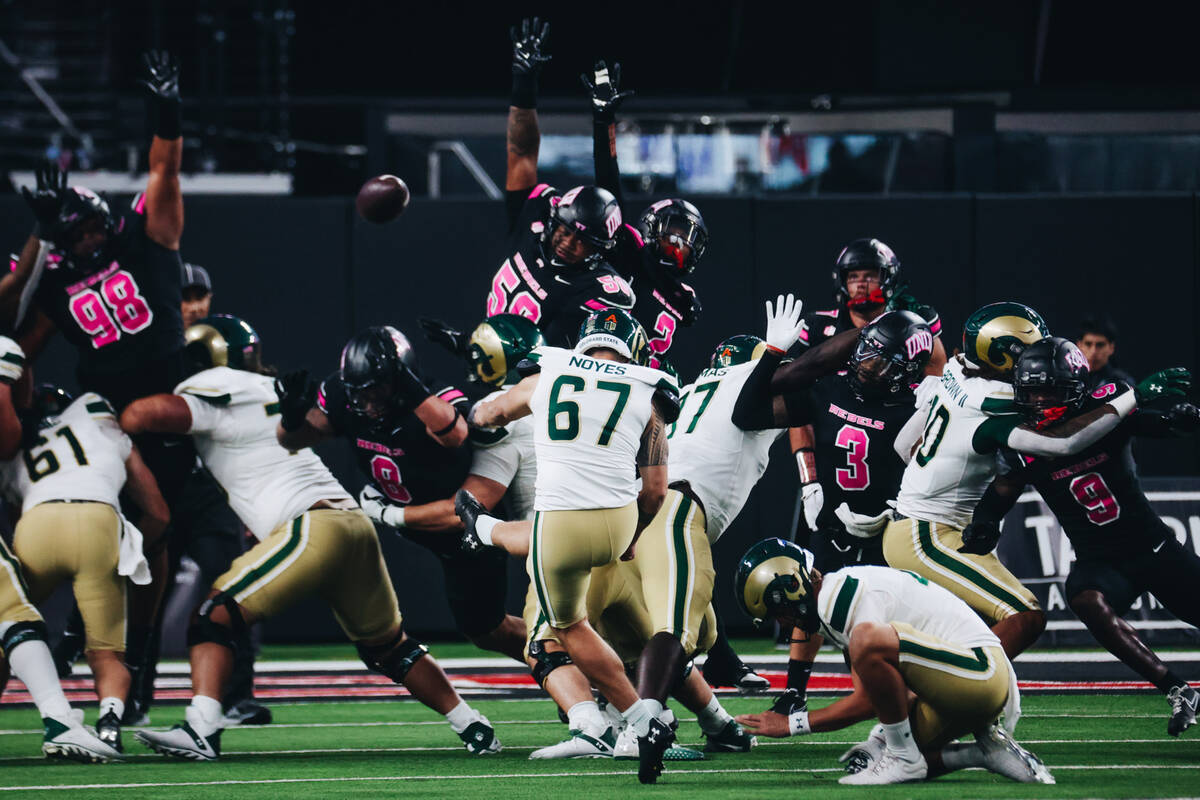 UNLV defenders try to block a field goal by Colorado State place kicker Jordan Noyes (67) durin ...