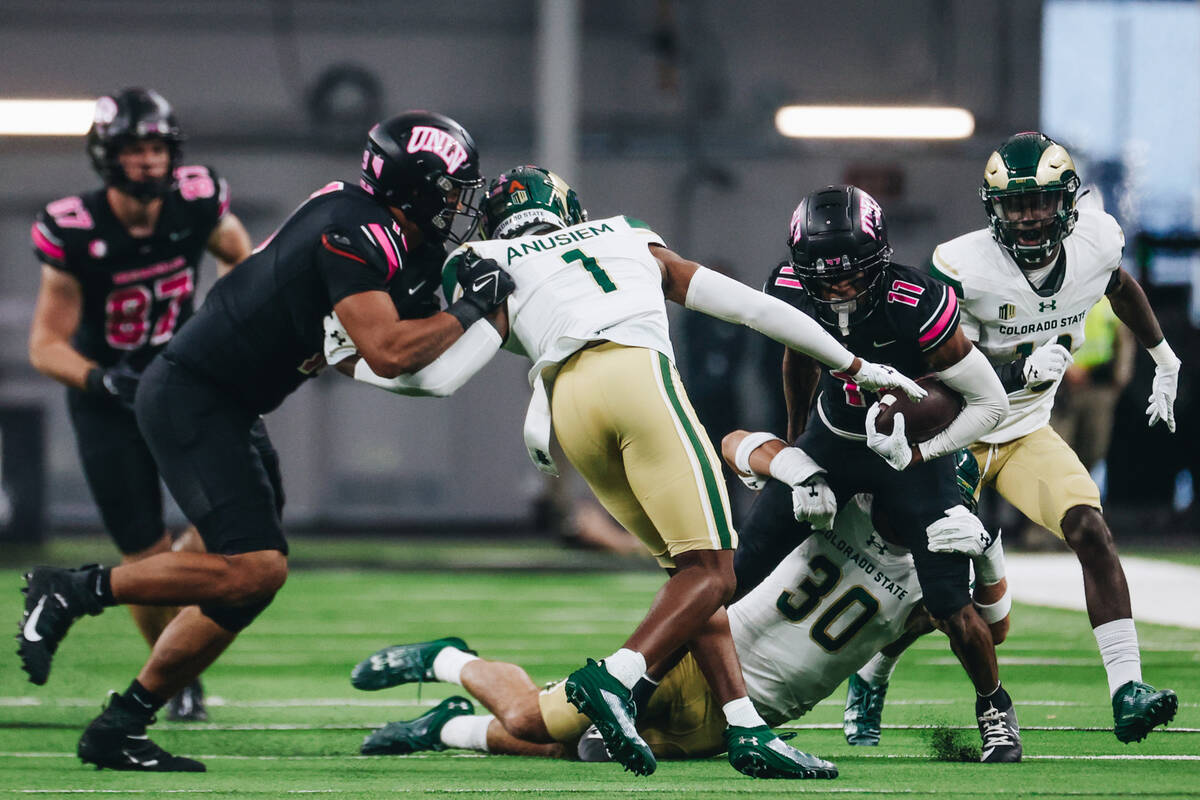 UNLV wide receiver Ricky White (11) makes his way past Colorado state defenders during a game a ...