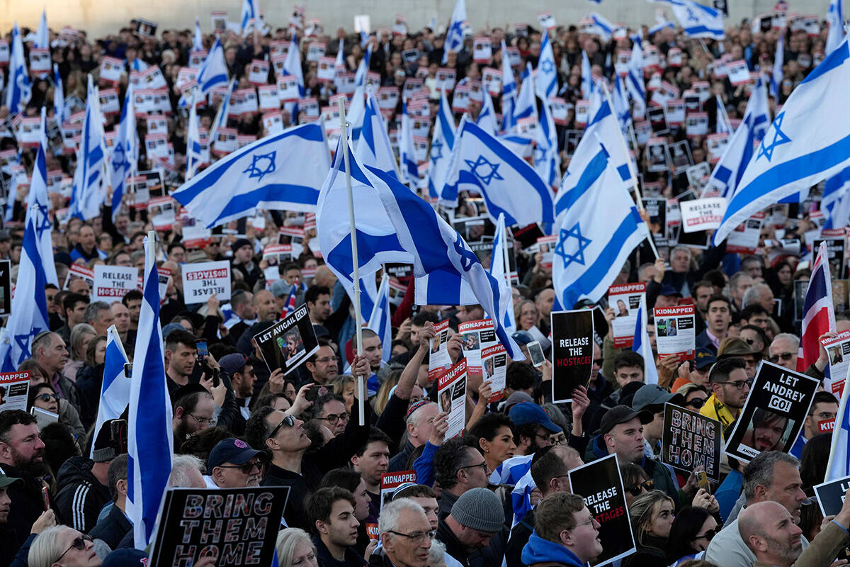 People carry Israeli flags and pictures of people believed taken hostage and held in Gaza, duri ...
