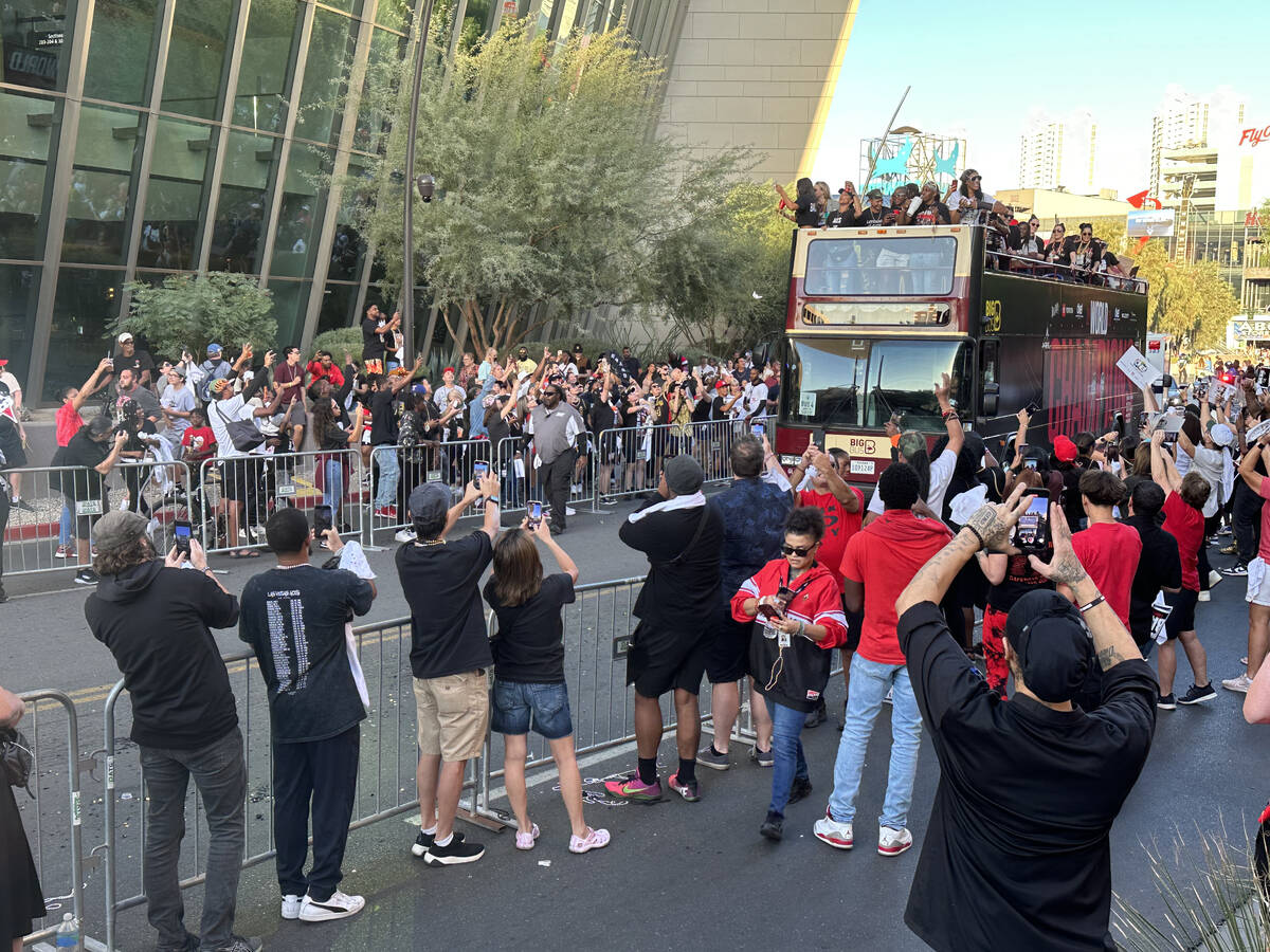 Fans watch the Las Vegas Aces head up the Las Vegas Strip on their way to a repeat world champi ...