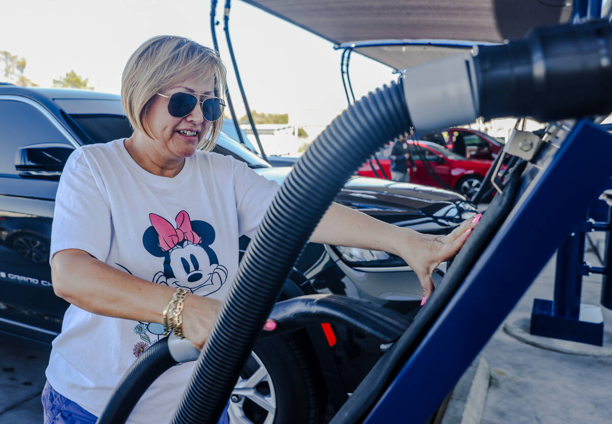 Customer Carol Conde vacuums her car mats at the Wow Carwash location on Pecos Road in Las Vega ...
