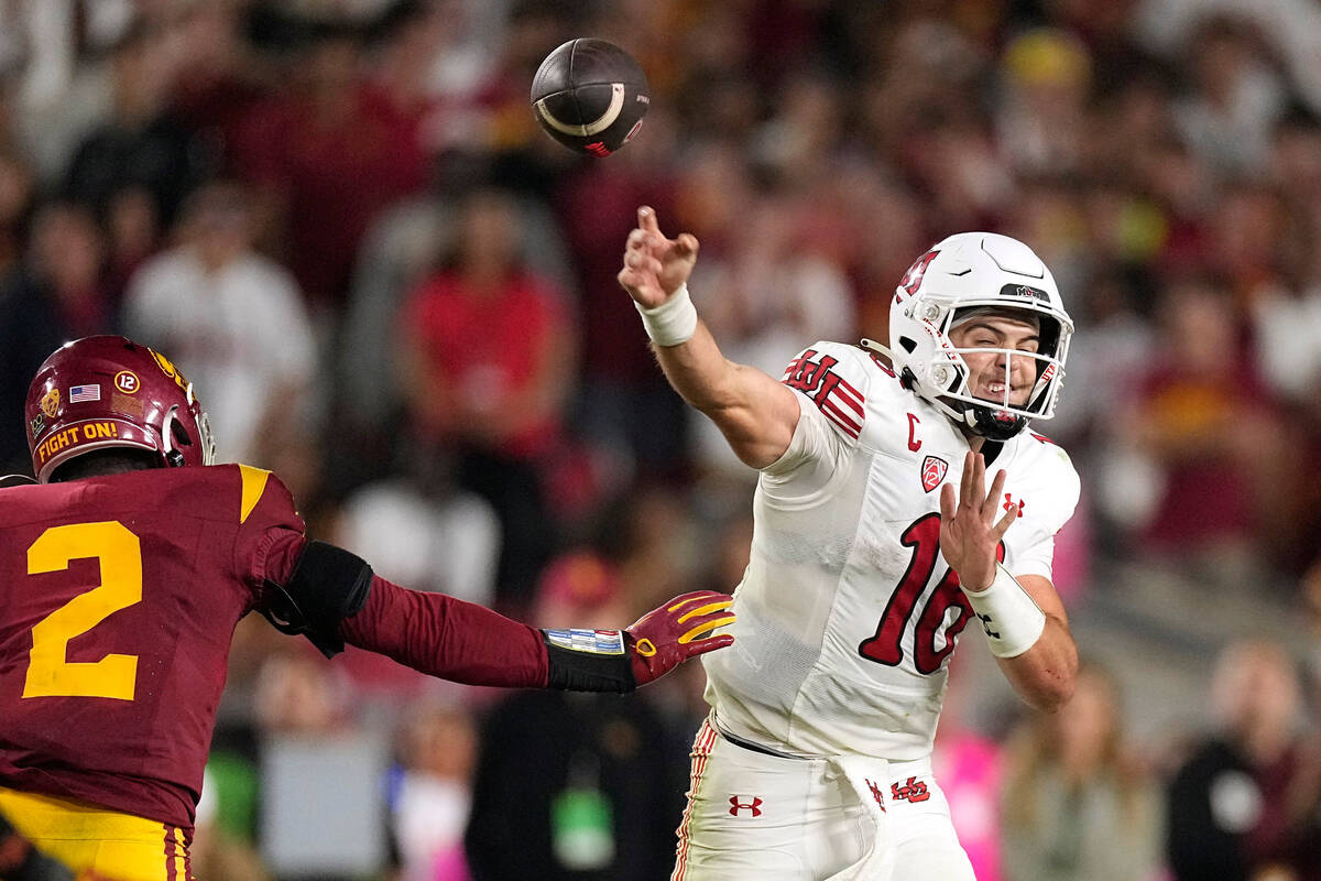 Utah quarterback Bryson Barnes, right, passes as Southern California defensive end Romello Heig ...