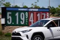 Gasoline prices are displayed outside a convenience store as a motorist drives by Thursday, May ...