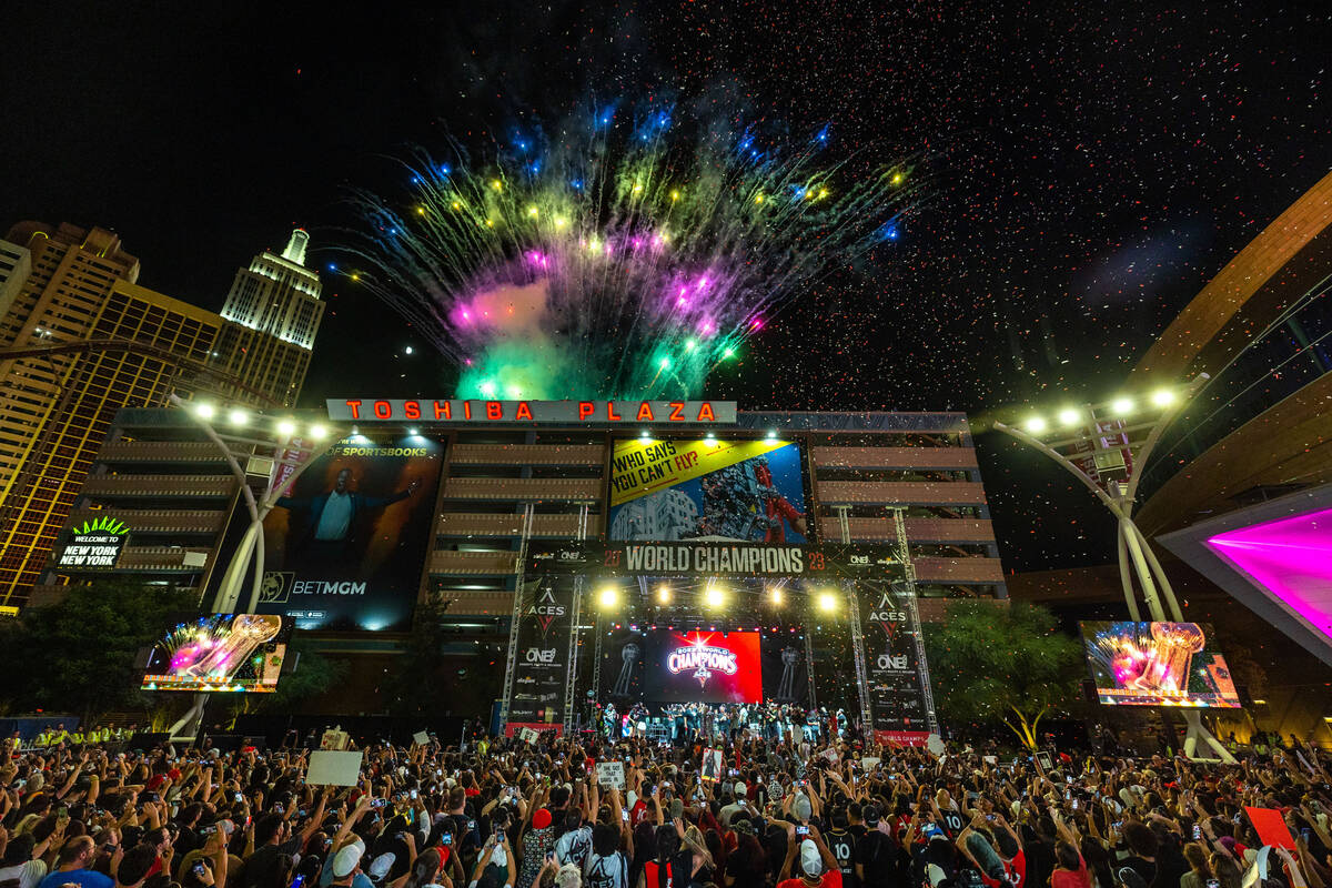 Aces players party on stage as fireworks erupt overhead during their championship celebration ...