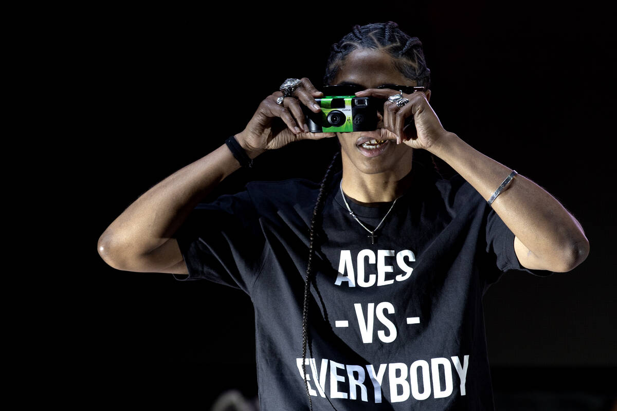 Las Vegas Aces guard Sydney Colson takes a photo from the stage during a celebration of her tea ...