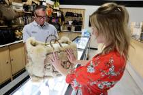 Owner Michael Mack shows a Fendi fur tote bag for sale at $12,000 to Kathryn Palmer at his Max ...