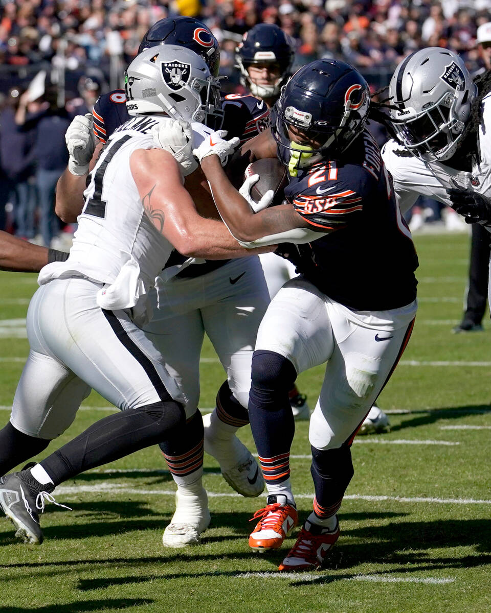 Chicago Bears running back D'Onta Foreman breaks through the tackle of Las Vegas Raiders lineba ...