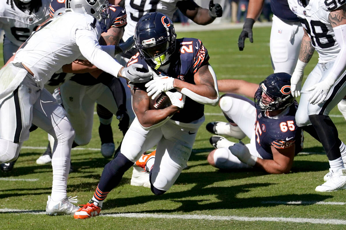 Chicago Bears running back D'Onta Foreman breaks through the tackle of Las Vegas Raiders lineba ...