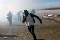 A migrant runs from tear gas launched by U.S. agents. (AP Photo/Rodrigo Abd)