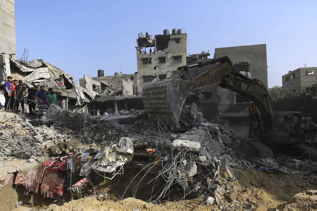 Palestinians inspect the damage of destroyed houses after Israeli airstrikes on Gaza City, Tues ...