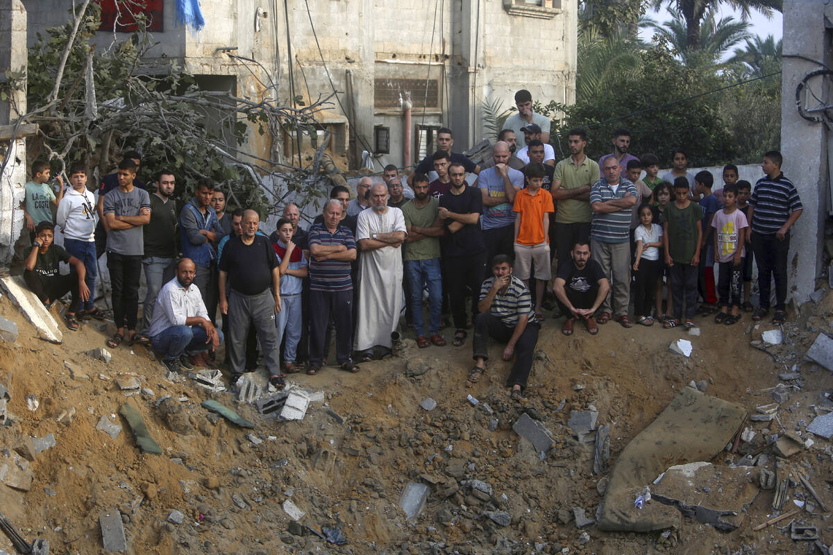 Palestinians inspect the damage of a destroyed house that was hit by an Israeli airstrike in to ...