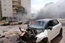 Cars are on fire after they were hit by rockets from the Gaza Strip in Ashkelon, Israel, on Sat ...