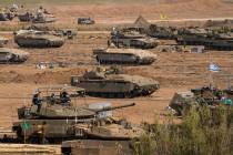 Israeli soldiers gather in a staging area near the border with the Gaza Strip on Tuesday, Oct. ...