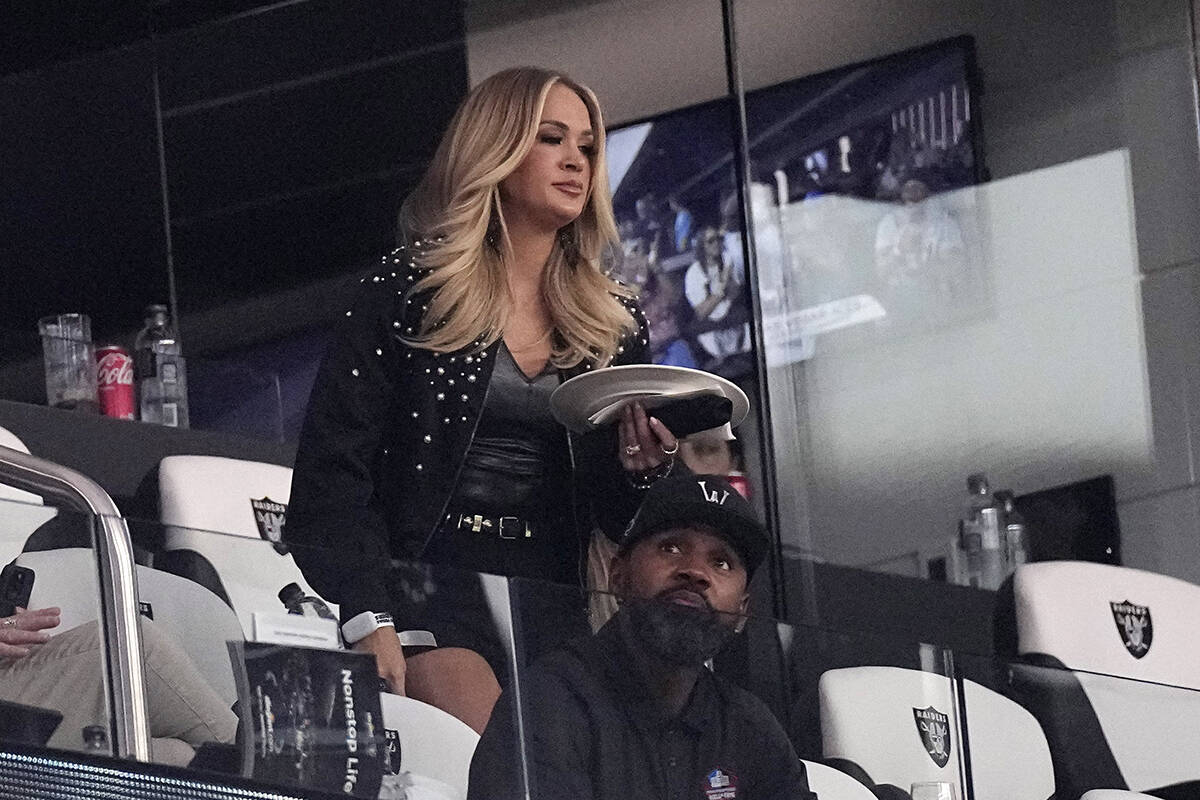 Singer Carrie Underwood, top, and former football player Charles Woodson attend an NFL football ...
