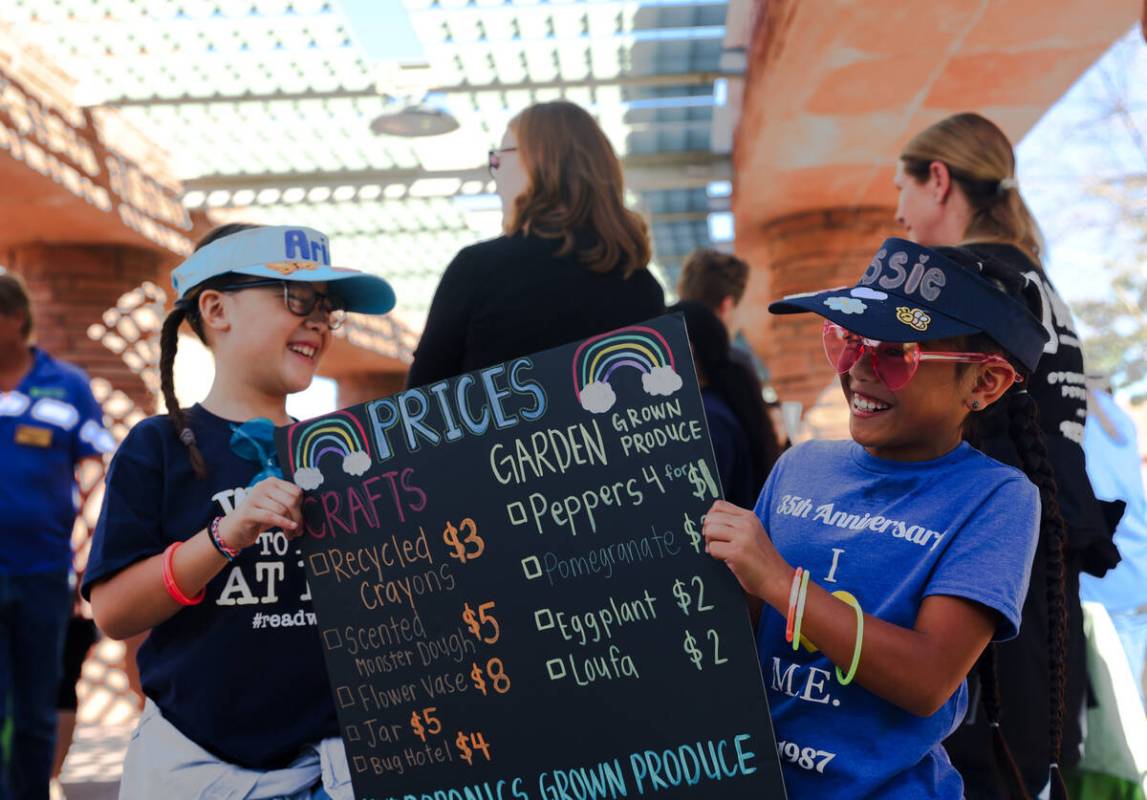 Ariani Peña, 9, left, and Jessie Cruz, 8, right, from Marion Earl Elementary School, hold a si ...