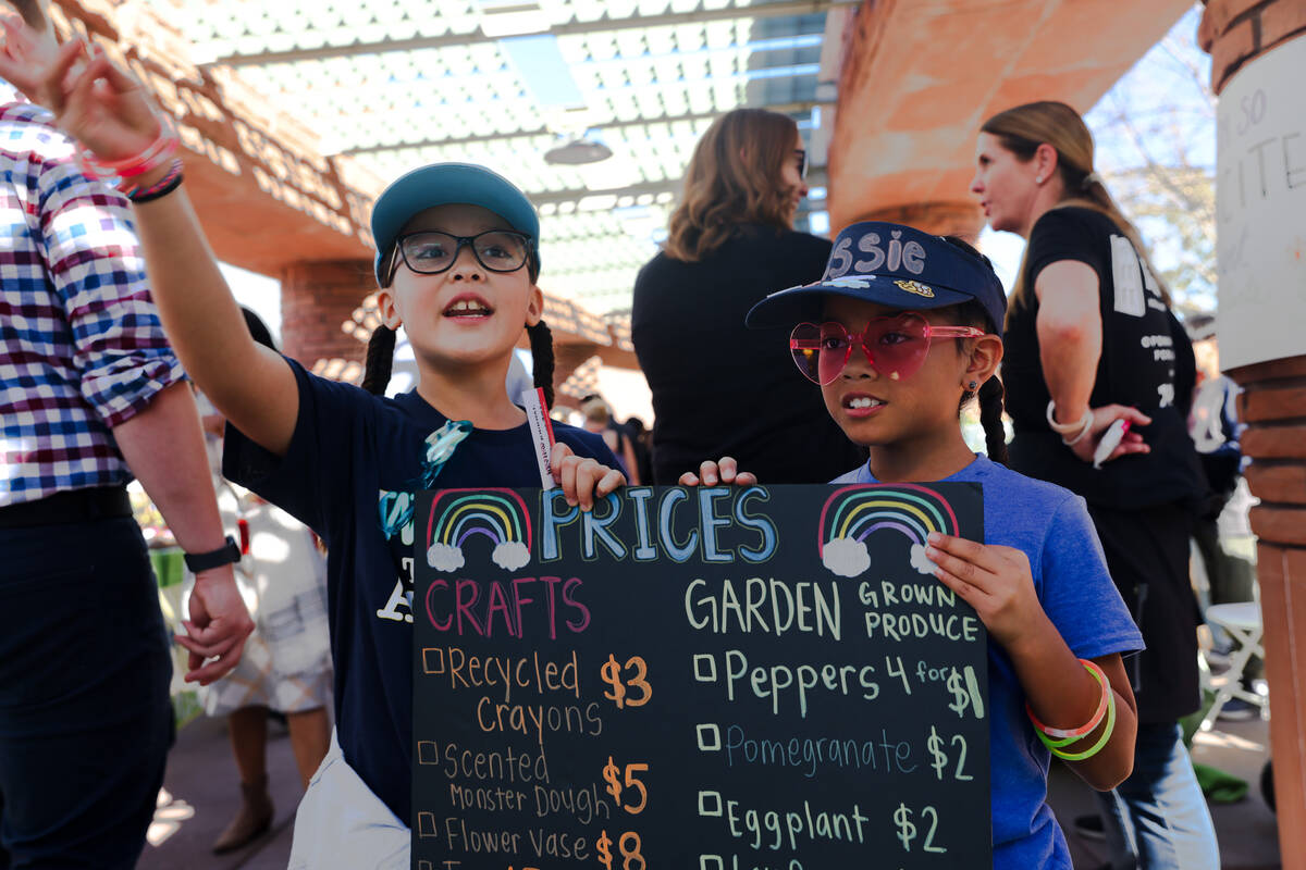 Ariani Peña, 9, left, and Jessie Cruz, 8, right, from Marion Earl Elementary School, hold a si ...