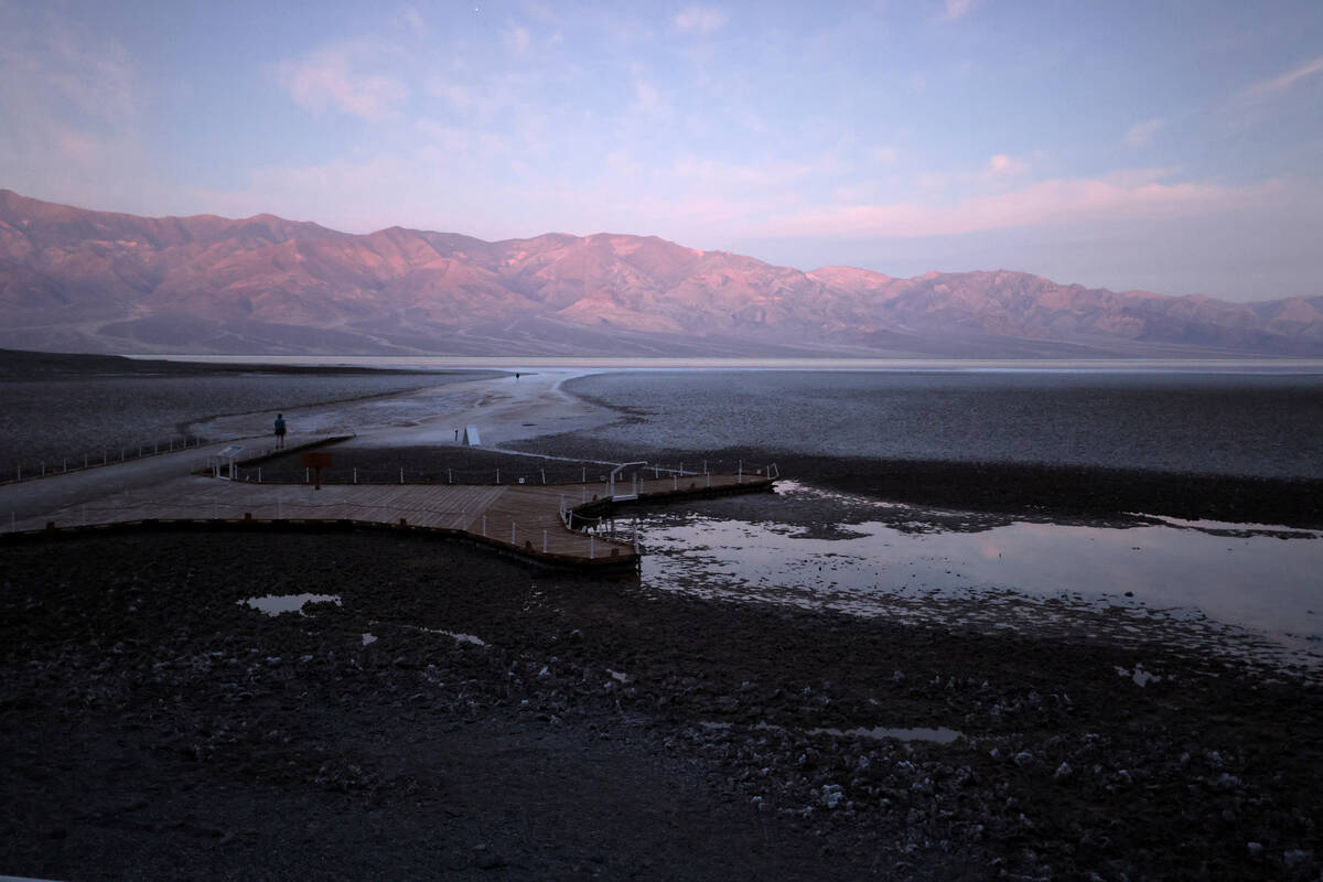 Visitors check out a rare lake in Badwater Basin in the recently reopened Death Valley National ...