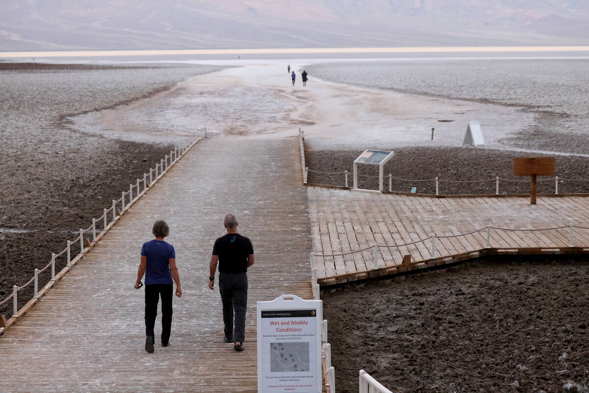 Visitors check out a rare lake in Badwater Basin in the recently reopened Death Valley National ...