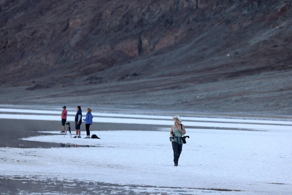 Visitors check out a rare lake in Badwater Basin in the recently reopened Death Valley National ...