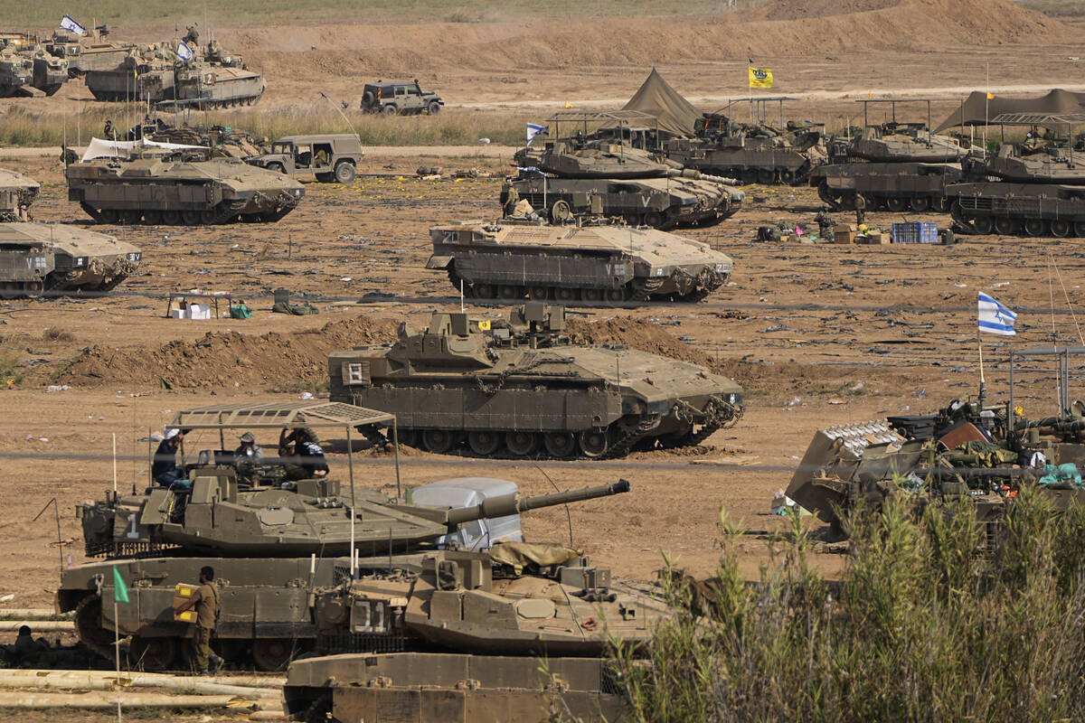 Israeli soldiers gather in a staging area near the border with Gaza Strip, in southern Israel, ...