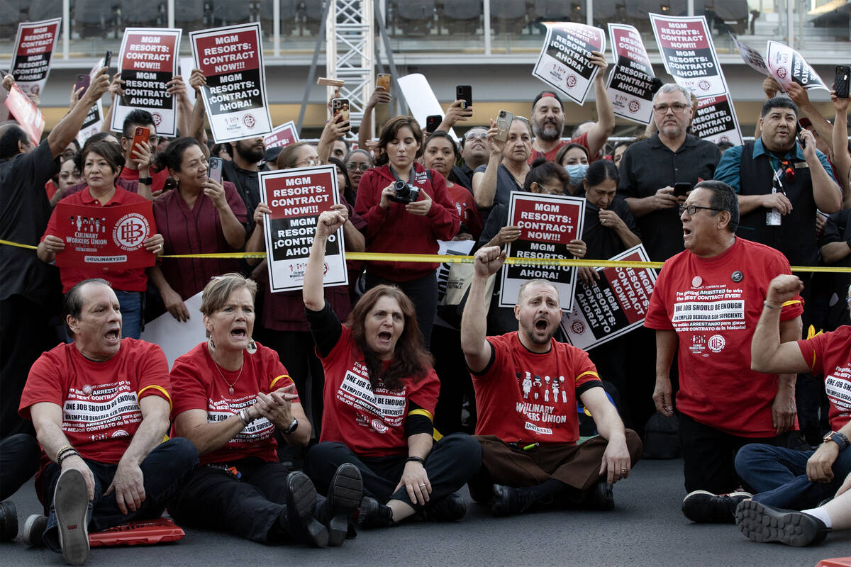 Culinary union members sit in the middle of Las Vegas Boulevard, blocking traffic, during a ral ...